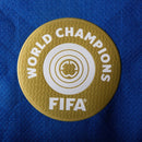 Patch de Campeão Mundial FIFA em fundo azul, parte do uniforme Chelsea home 25/26.