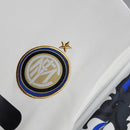Logo da Inter de Milão em camisa retro 10/11, destaque para detalhes em dourado e azul.