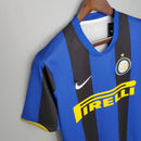Camisa retro Inter de Milão 08/09 com listras azuis e pretas, logo da Nike e detalhe Pirelli.