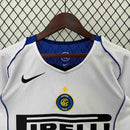 Camisa retrô do Inter de Milão 04/05, com logo e detalhes em azul, pendurada em um cabide.