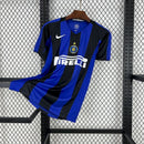 Camisa retro Inter de Milão 04/05 com listras azuis e pretas, fabricada pela Nike, em exibição em expositores.