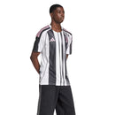 Camisola principal da Juventus 2025/26 da Adidas, com riscas pretas e brancas irregulares, gola TEAMGEIST, e detalhes em rosa no escudo e logos.