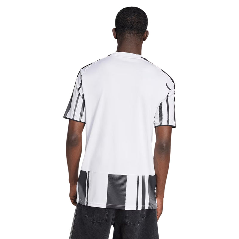 Camisola principal da Juventus 2025/26 da Adidas, com riscas pretas e brancas irregulares, gola TEAMGEIST, e detalhes em rosa no escudo e logos.