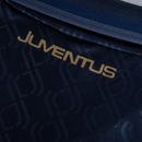 Detalhe da camisola Juventus third 24/25 com logo em dourado sobre fundo escuro. Olympic