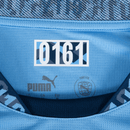 Detalhe da etiqueta do uniforme Manchester City home 24/25 azul, mostrando o logo da Puma e o número 0161.