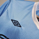 Camisa Manchester City Home 11/12 Retro com detalhes em azul e logo da Umbro visível.