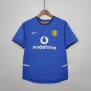 Camisa azul retrô do Manchester United Away 02/04 com logo da Nike e do clube.