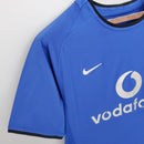Camisa azul retrô Manchester United Away 02/04 com detalhes da Nike e logo Vodafone.