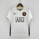 Camisa retrô do Manchester United Away 06/07 com detalhes em dourado e logo do clube.