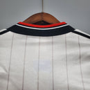 Parte de trás da camisa retro do Manchester United Away de 1983, destacando o colarinho e as listras.