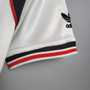 Camisa retro do Manchester United Away 1985 com detalhes Adidas, parte da manga em foco.