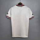 Camisa retrô Manchester United Away 1985, visual traseiro em tecido branco e detalhes em vermelho e preto.