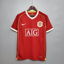 Camisa retrô Manchester United 06/07, destacando cores tradicionais e logo AIG, perfeita para fãs do futebol.