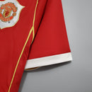 Camisa retrô Manchester United Home 06/07, mostrando detalhes da mangas e logo do time.