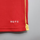 Detalhe da camiseta retrô do Manchester United 06/07 com logo MUFC em destaque.