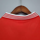 Detalhe da gola da camisa retrô Manchester United Home 1977, com listras brancas e vermelhas.