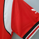 Camisa retrô Manchester United Home 1985, detalhe das mangas vermelha e branca da Adidas.