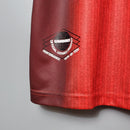 Detalhe da camisa retro do Manchester United Home 1996 mostrando o emblema Umbro oficial.