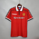 Camisa Manchester United Home 98/99 Retro, vermelha, com detalhes em preto e branco, da marca Umbro.