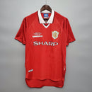 Camisa retrô Manchester United 99/00 com detalhes em vermelho e logo Umbro. Ideal para torcedores.