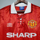 Camisa retrô do Manchester United 92/94 com detalhes em vermelho e logo do clube na parte frontal.