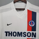 Camiseta PSG Away 02/03 Retro branco com detalhes em vermelho e azul, logo da Nike e patrocinador Thomson.