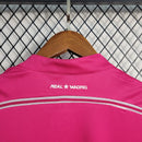 Detalhe das costas da camisola rosa do Real Madrid, destacando o logo e o design retro.