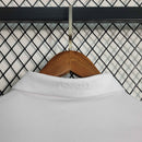 Camisola retrô branca Real Madrid 16/17 com logo na gola, pendurada em cabide.